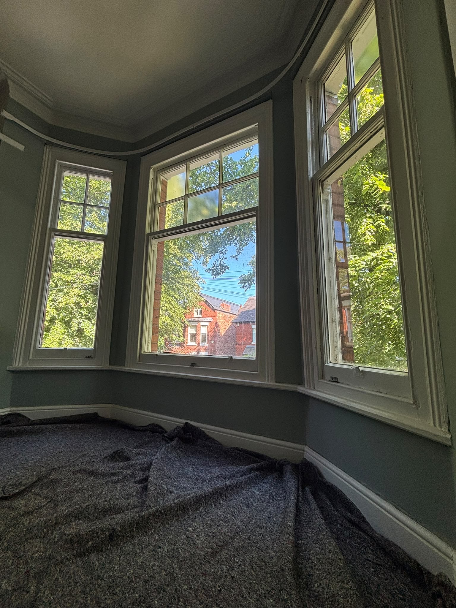 Interior bay with original timber sash windows in a Chorlton period home before replacement