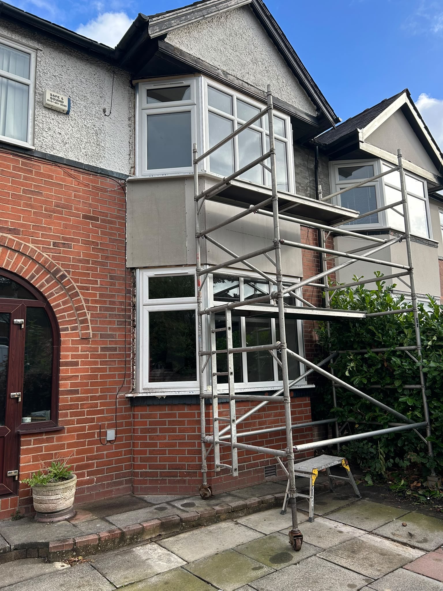 Scaffold tower in front of the bay during window and middle-section installation.