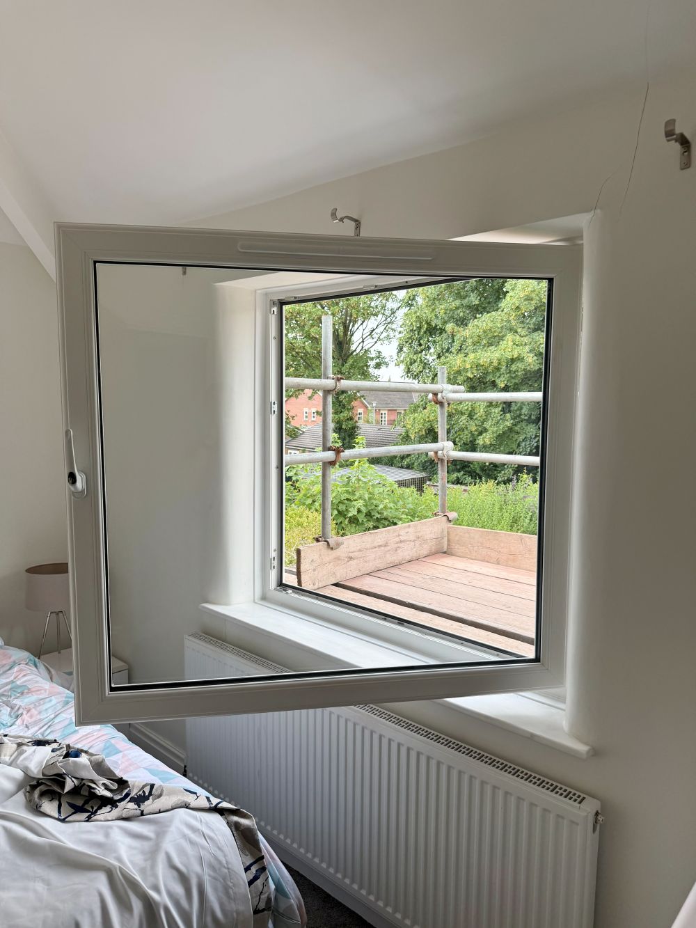 Large white tilt-and-turn window fully open in an Altrincham home