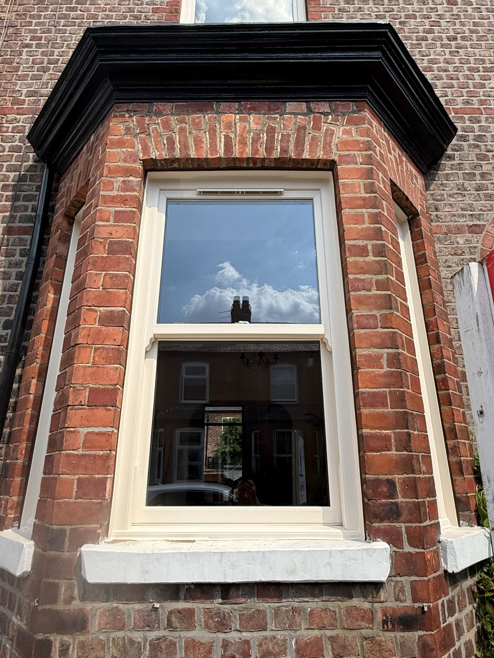 Cream woodgrain uPVC sliding sash window fitted in a Victorian bay in Altrincham