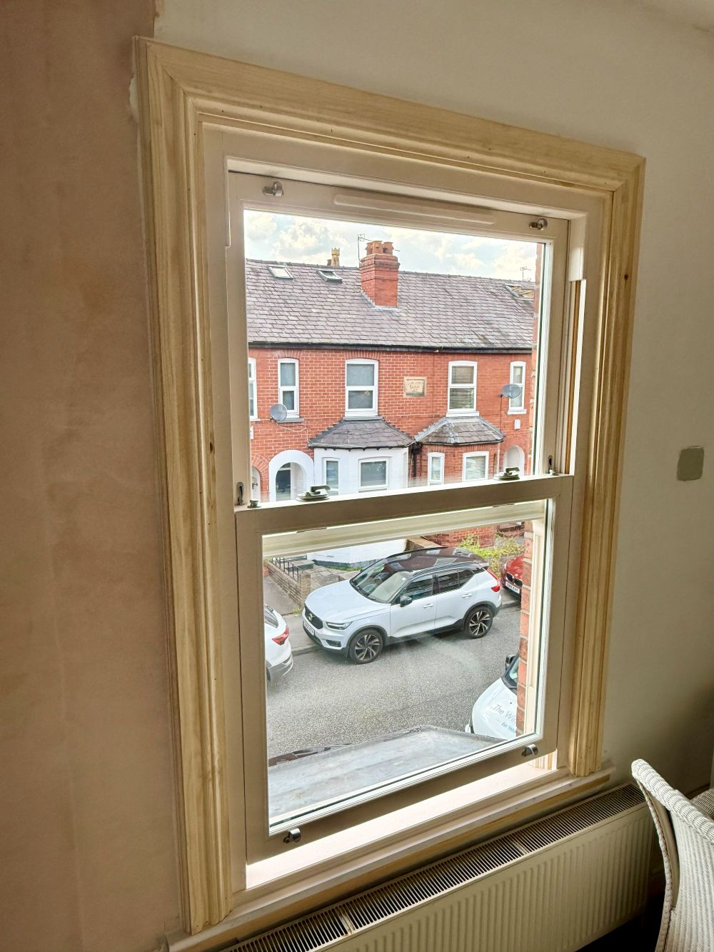 Interior view of cream sliding sash window with moulded timber architrave