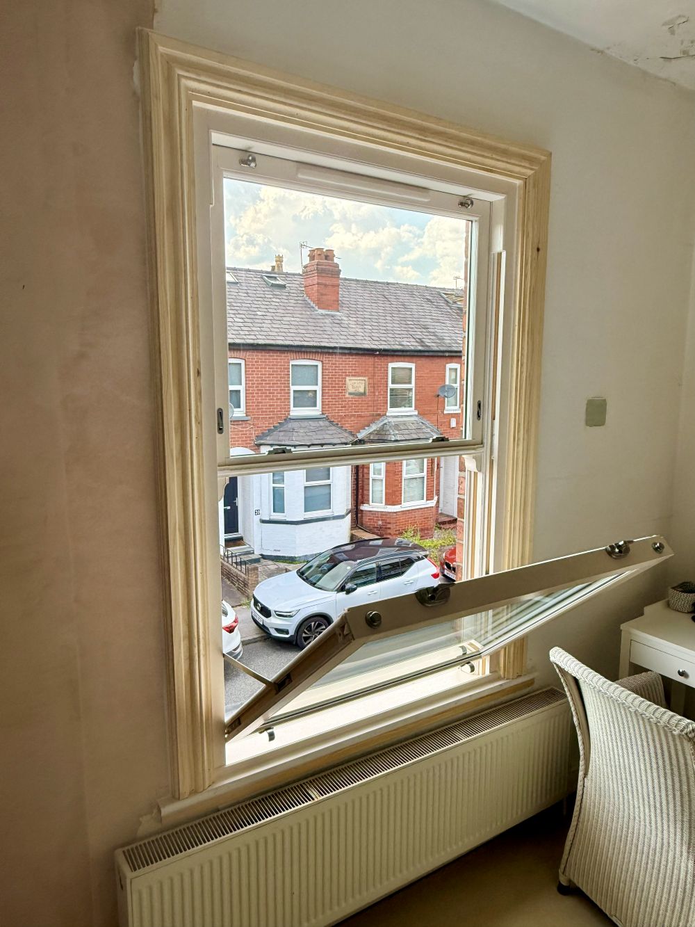 Cream sliding sash window with timber architrave viewed from inside an Altrincham home