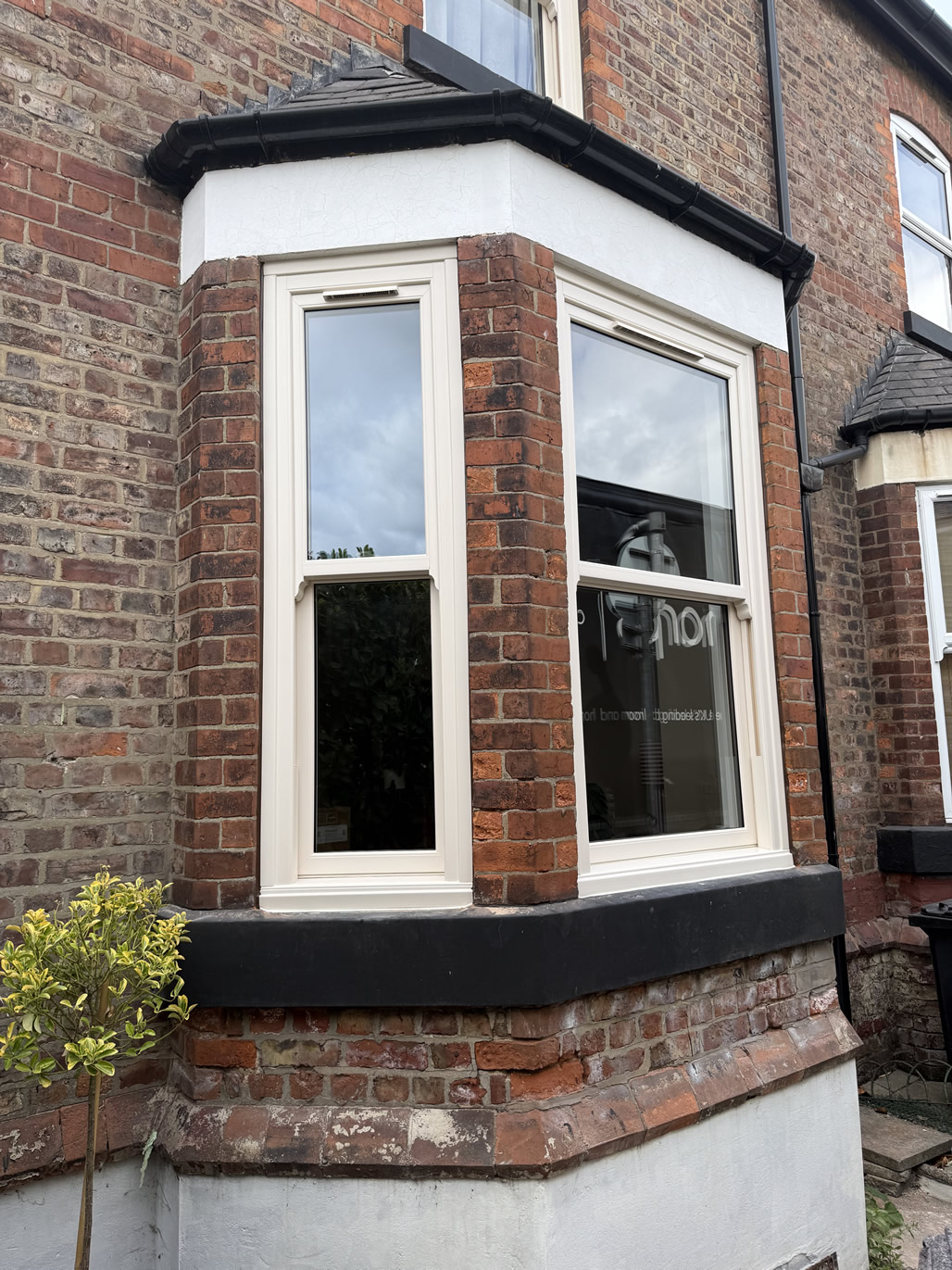 Cream sash windows fitted within brick bay of period home in Urmston
