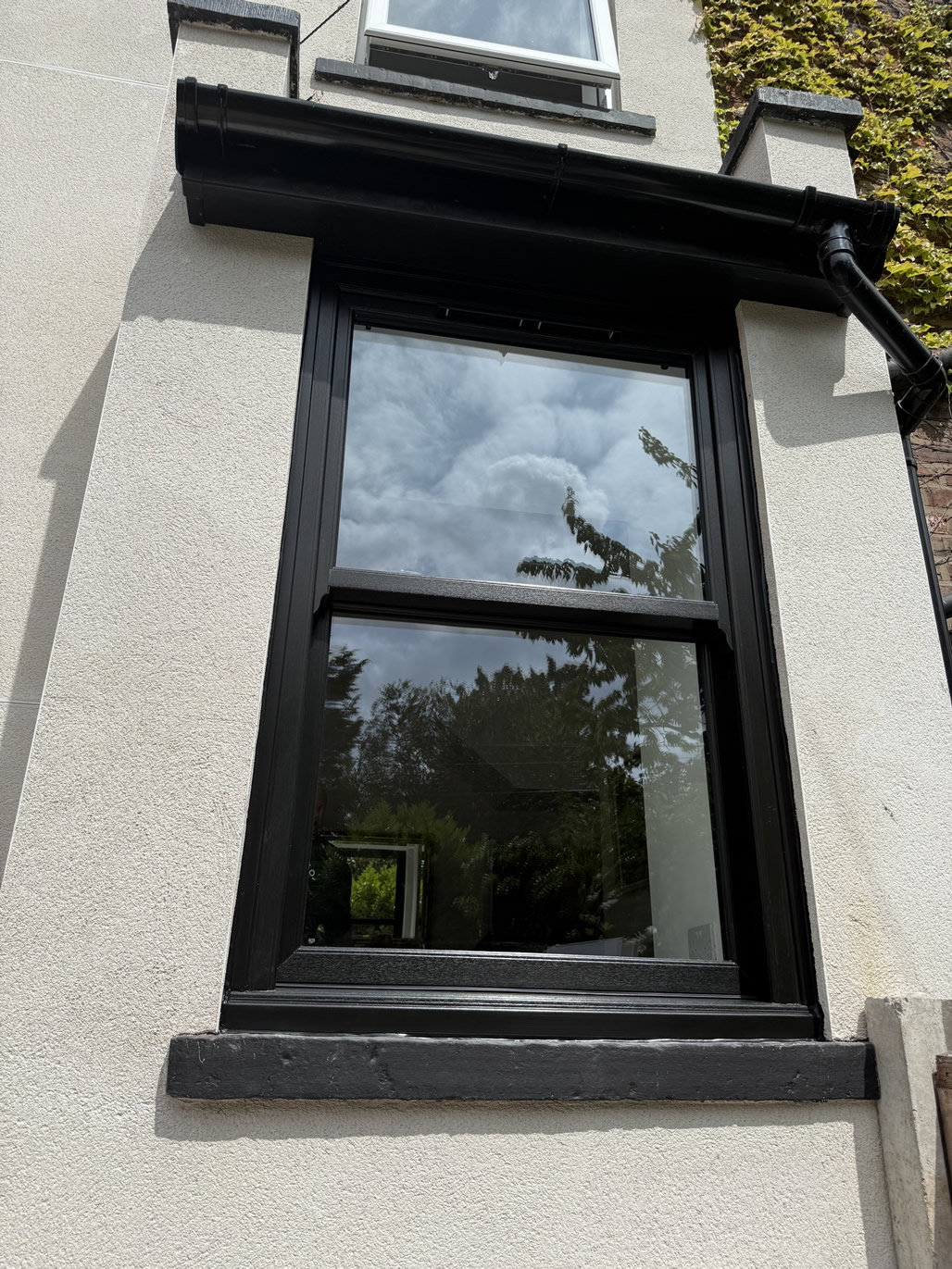 Anthracite grey sash window installed to rear of rendered period home in Urmston