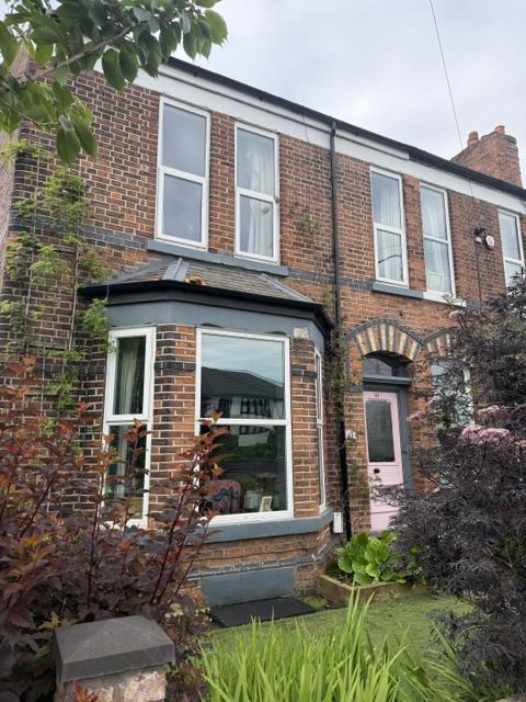 White uPVC casement windows in the front bay and upper floor before replacement in Sale.