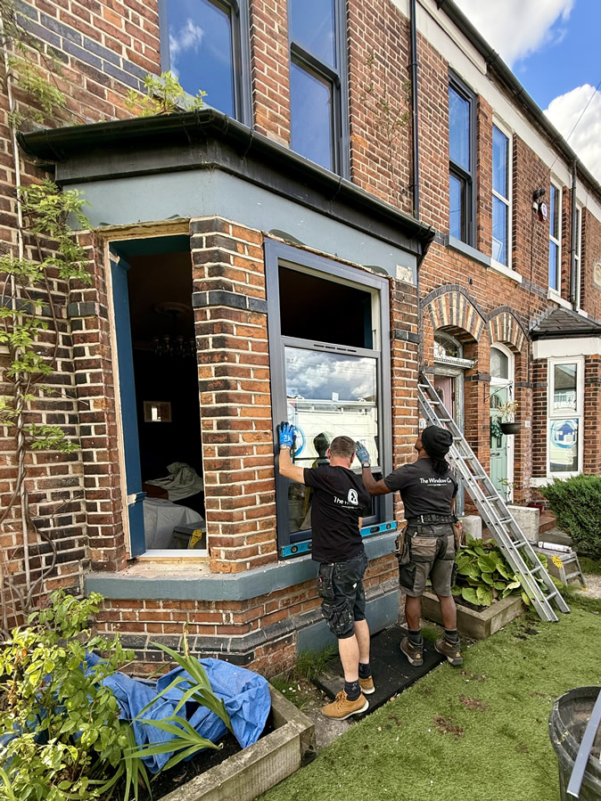 Two Window Company installers working on the front bay sash window installation in Sale.